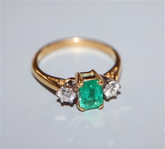 A modern 18ct gold, emerald and diamond three stone ring, size O.